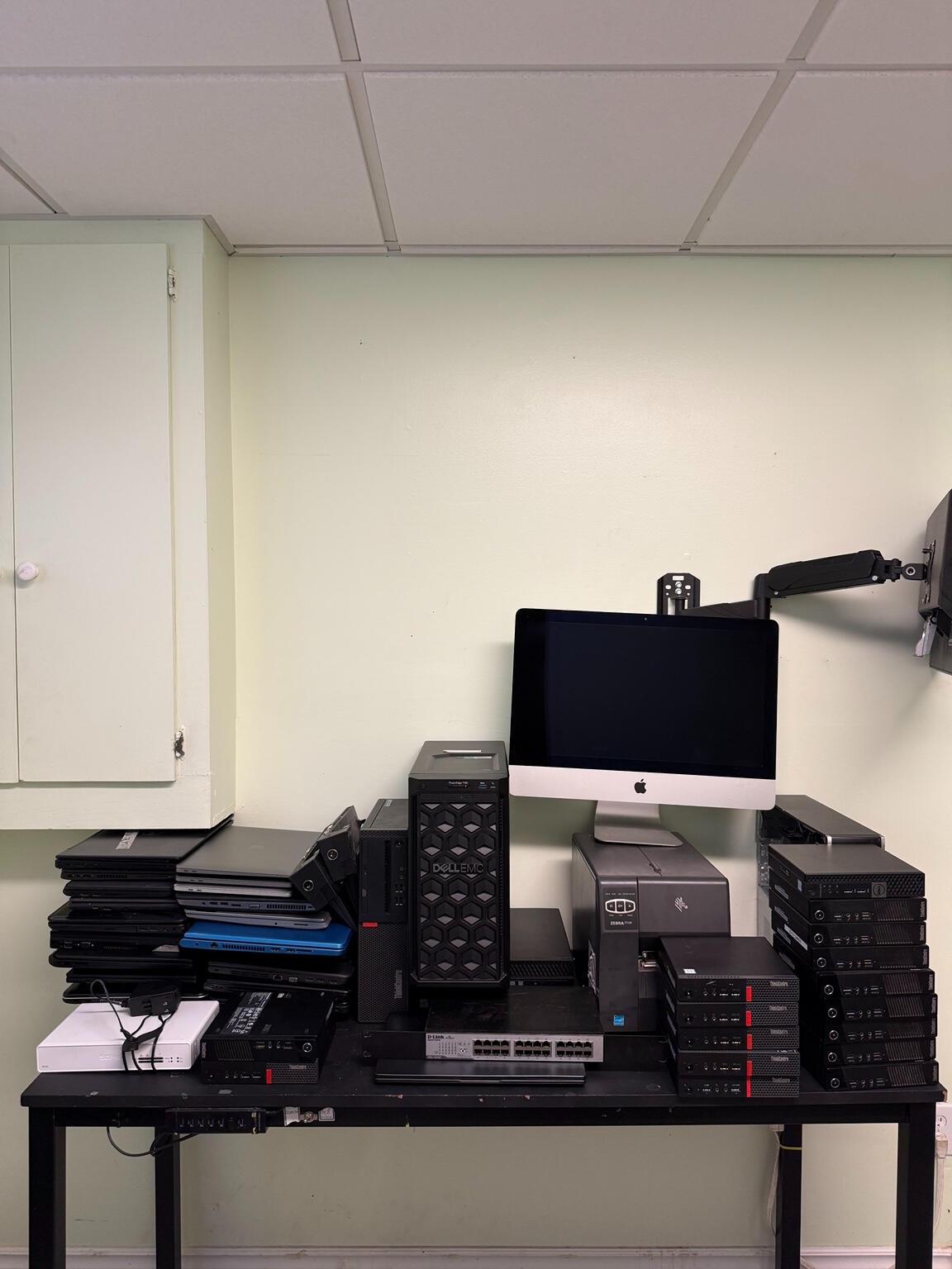 Mixed retired IT equipment including laptops, desktops, server and networking hardware.